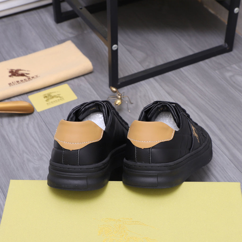 Black Burberry low-top sneakers with tan heel tabs and ridged rubber sole.