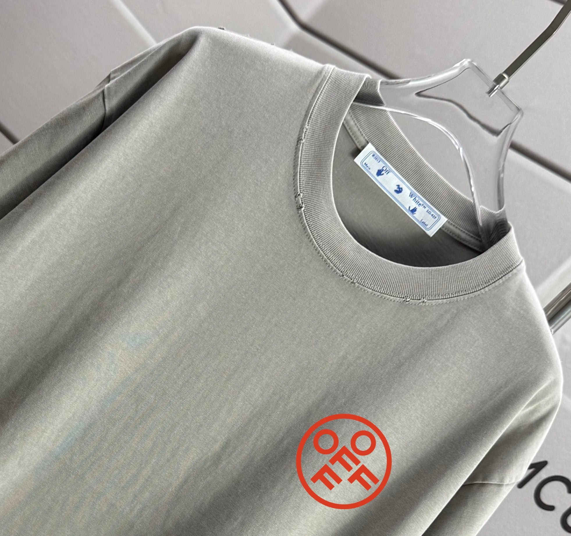Gray crewneck T-shirt neckline with inner label and circular chest logo