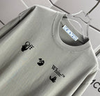 Light gray crewneck T-shirt neckline with logo prints and tag