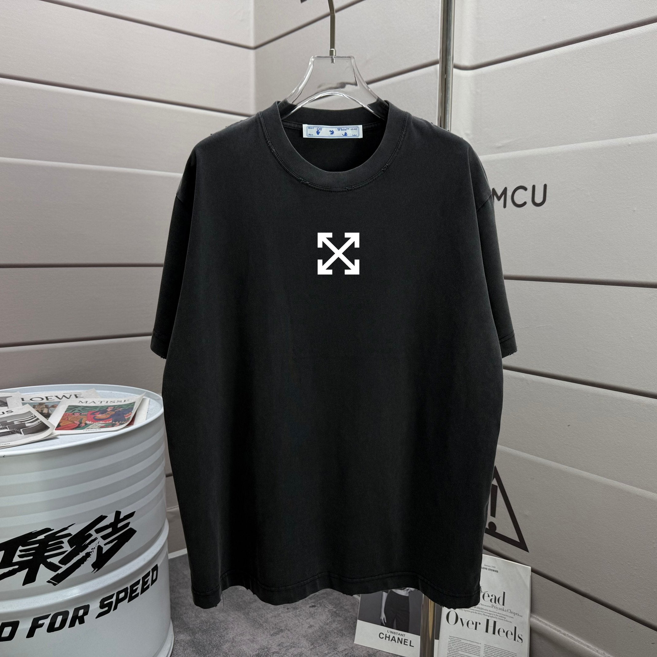 Black T-shirt with small white arrow-cross graphic on chest