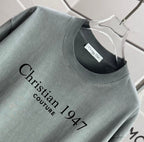 Crewneck T-shirt in muted gray-green with black 'Christian 1947 Couture 1047' graphic