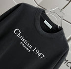 Black T-shirt neckline with “Christian 1947 Couture” logo print