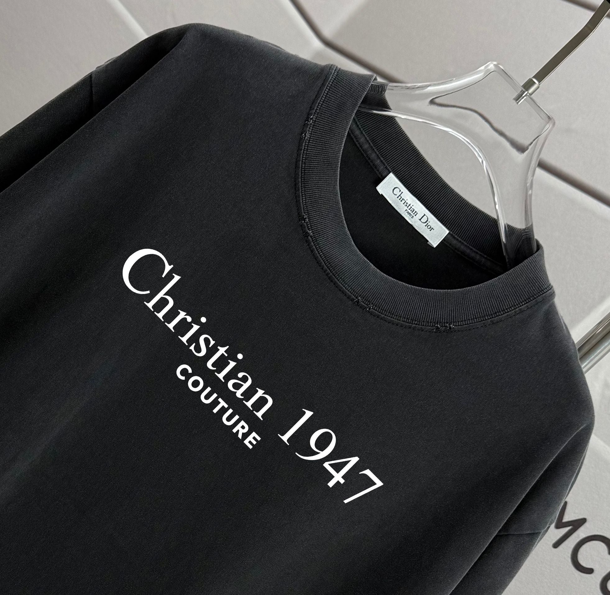 Black T-shirt neckline with “Christian 1947 Couture” logo print