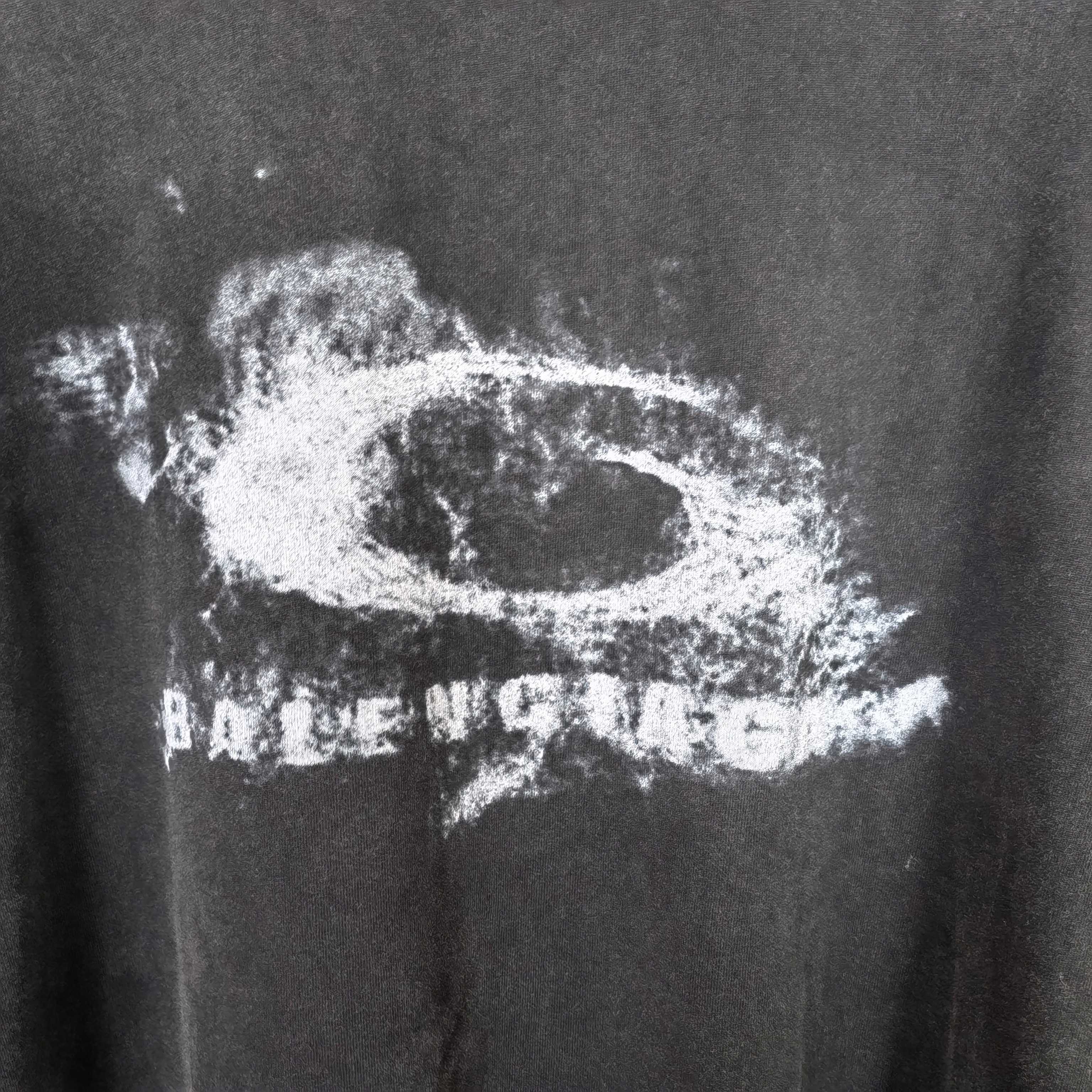 Close-up of dark T-shirt fabric with large white eye graphic and distressed text