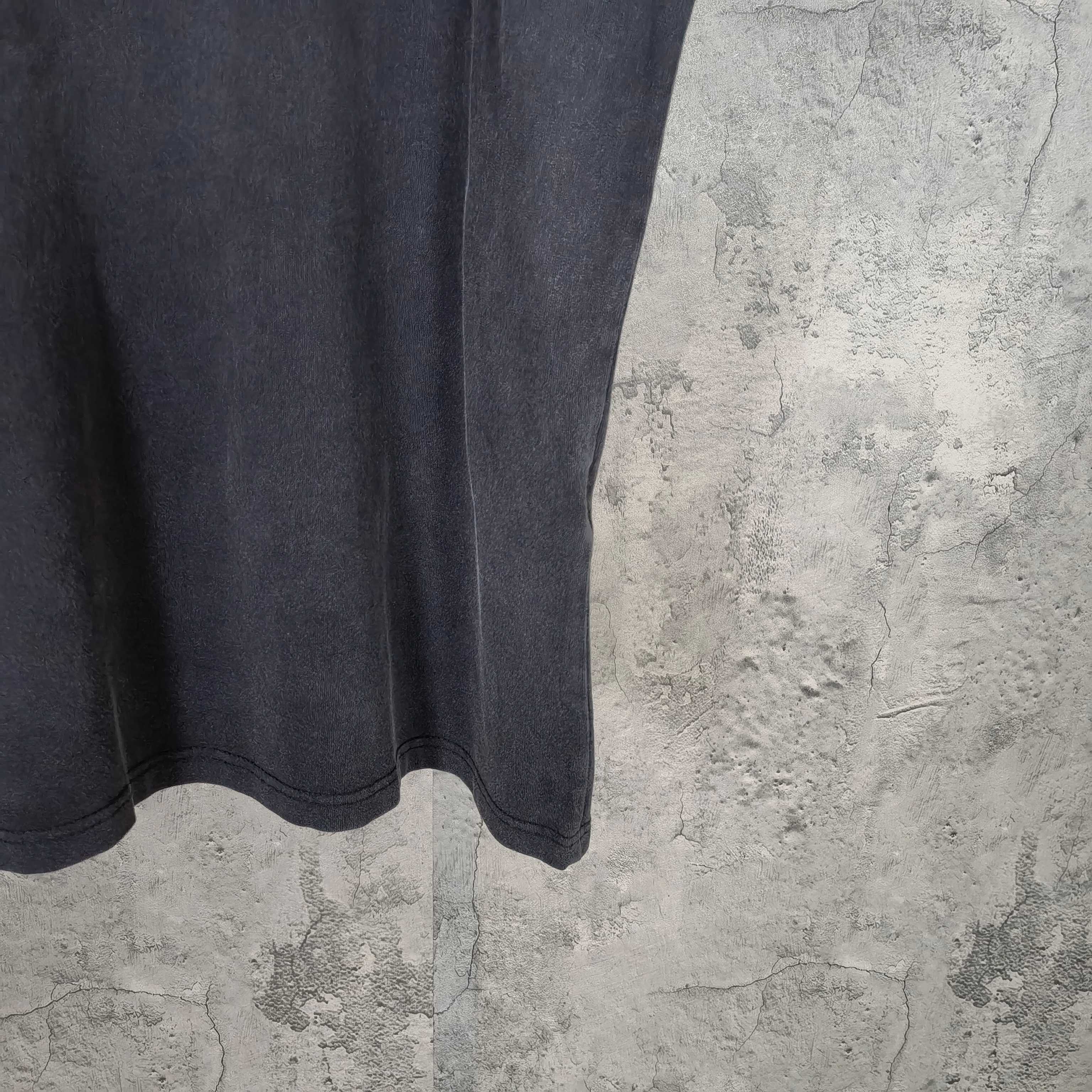 Dark wash T-shirt hem view with straight bottom edge and subtle wear marks