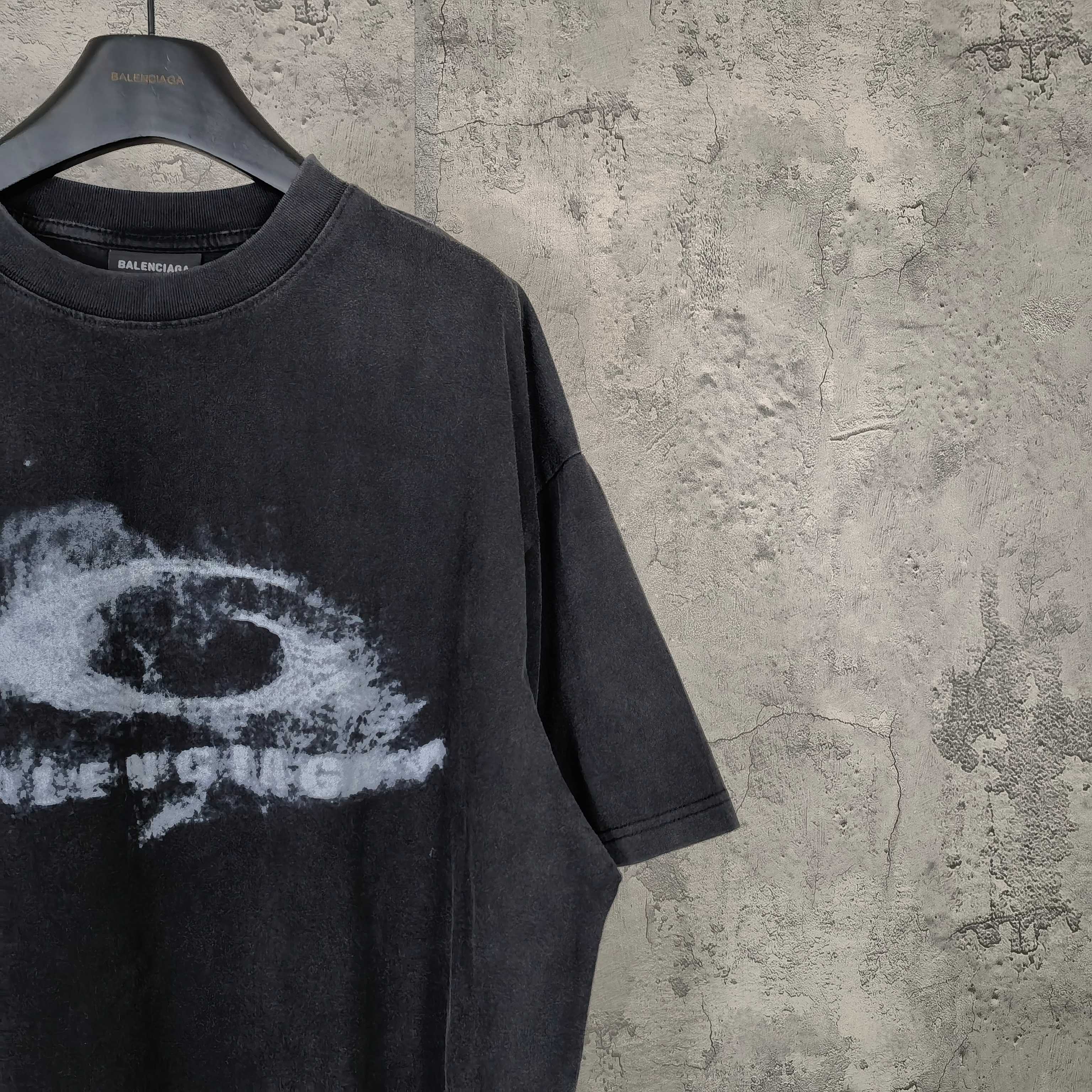 Dark wash T-shirt detail with partial white eye graphic and short sleeve