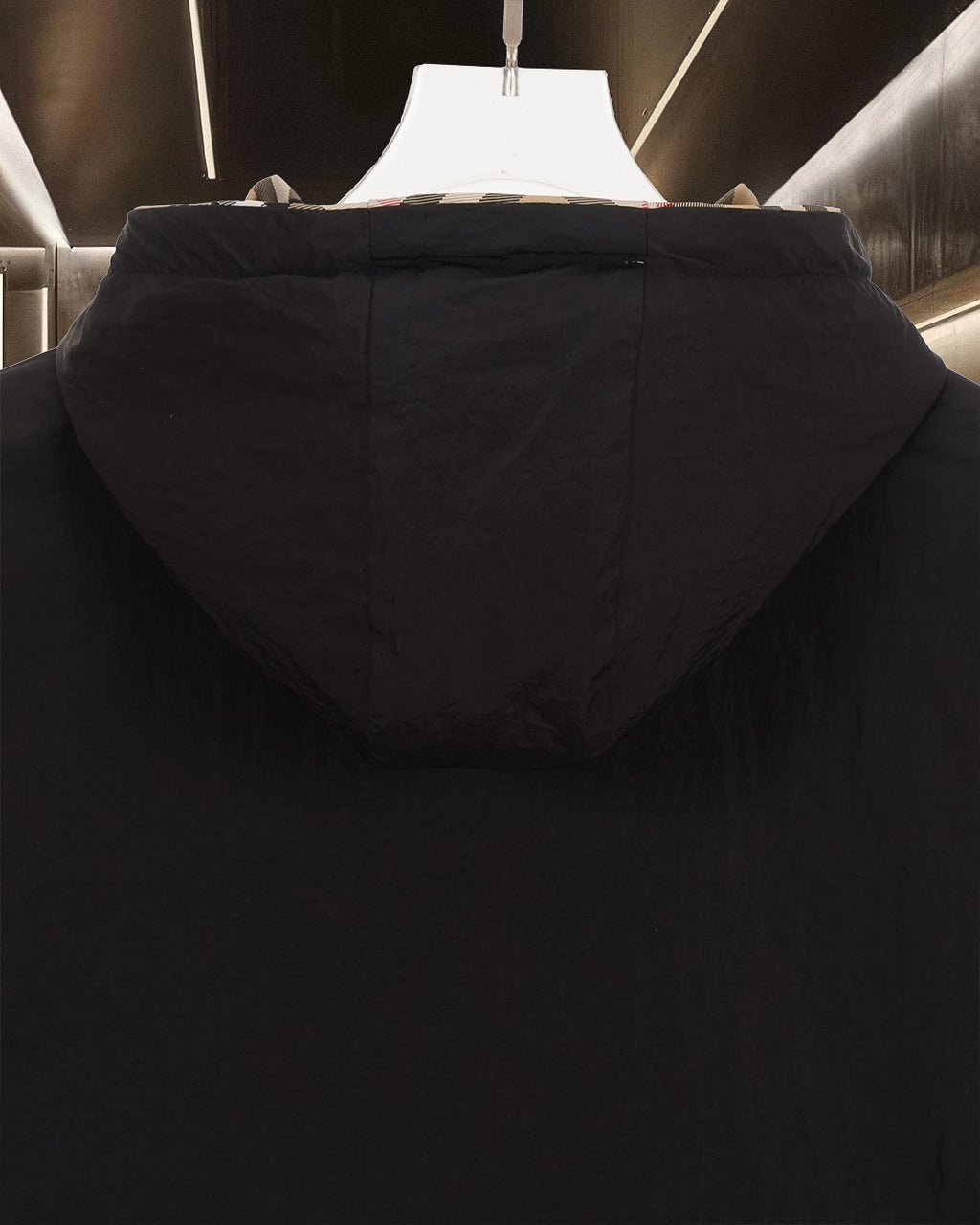 Long hooded jacket in dark color with pouch pocket, shown from the back