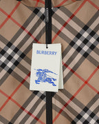 Burberry hang tag on beige, black, and red plaid fabric of a hooded jacket