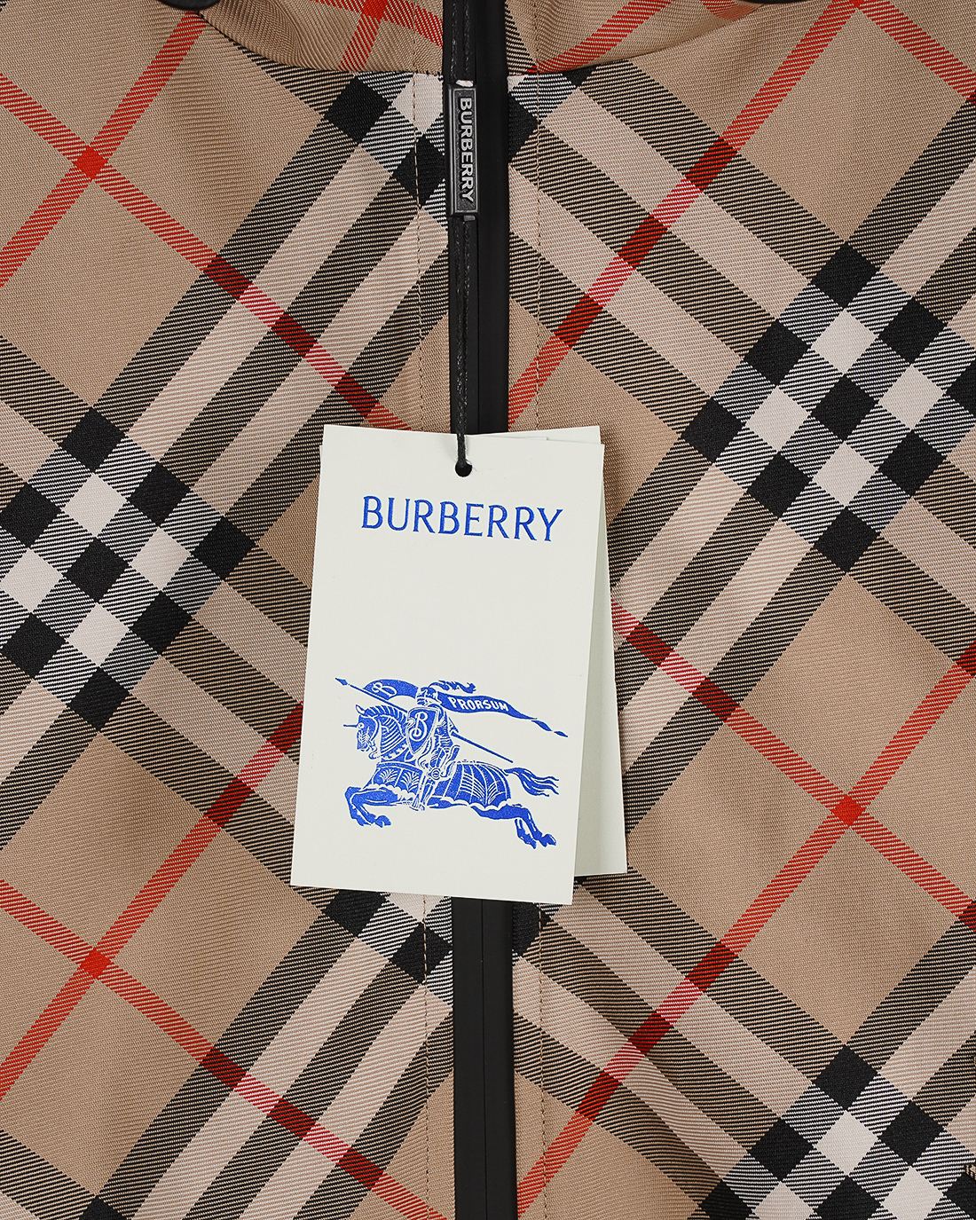 Burberry fabric tag attached to the front of a beige plaid hooded jacket