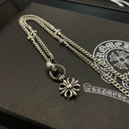 Silver-tone chain necklace with snowflake charms and clasp on black jewelry box