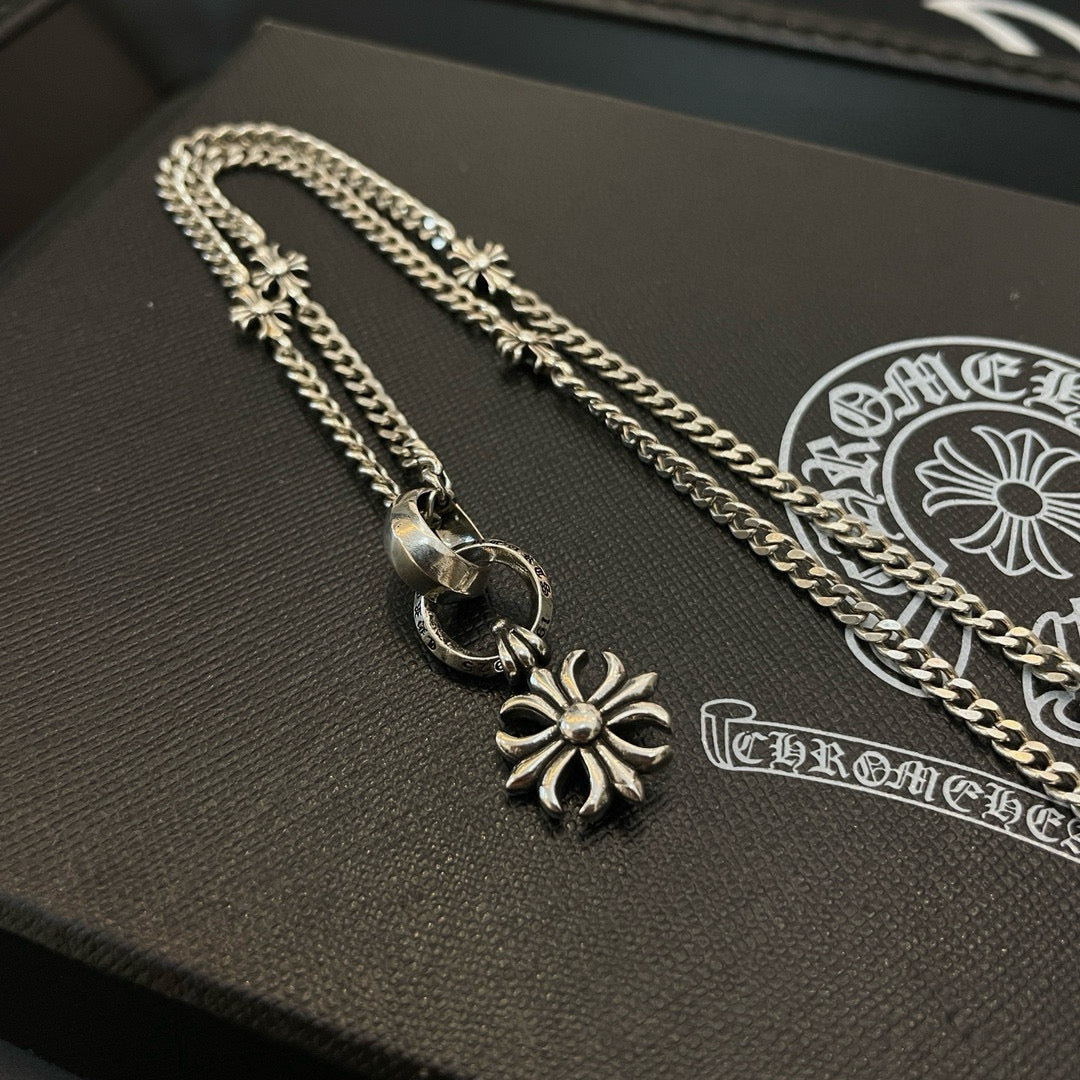 Silver-tone chain necklace with snowflake charms and clasp on black jewelry box