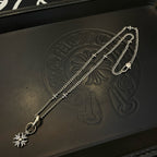Silver-tone chain necklace with snowflake charm on dark leather pouch