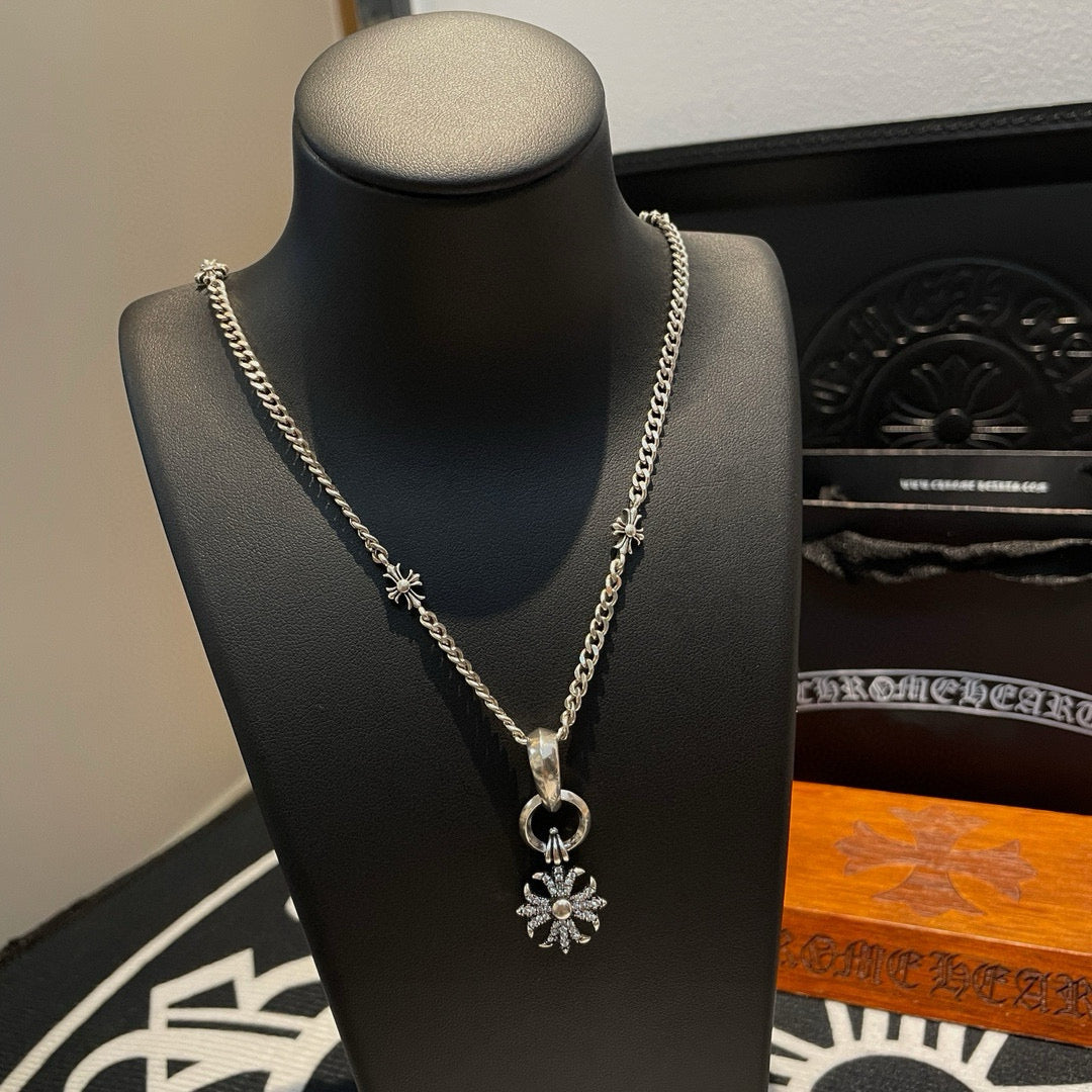 Silver-tone chain necklace on black bust with snowflake pendant and loop clasp