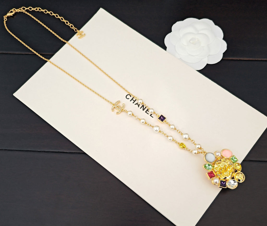 Gold-tone layered necklace with floral pendant, pearls, and CC charm link