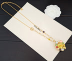 Gold-tone layered necklace with floral pendant, pearls, and CC charm link