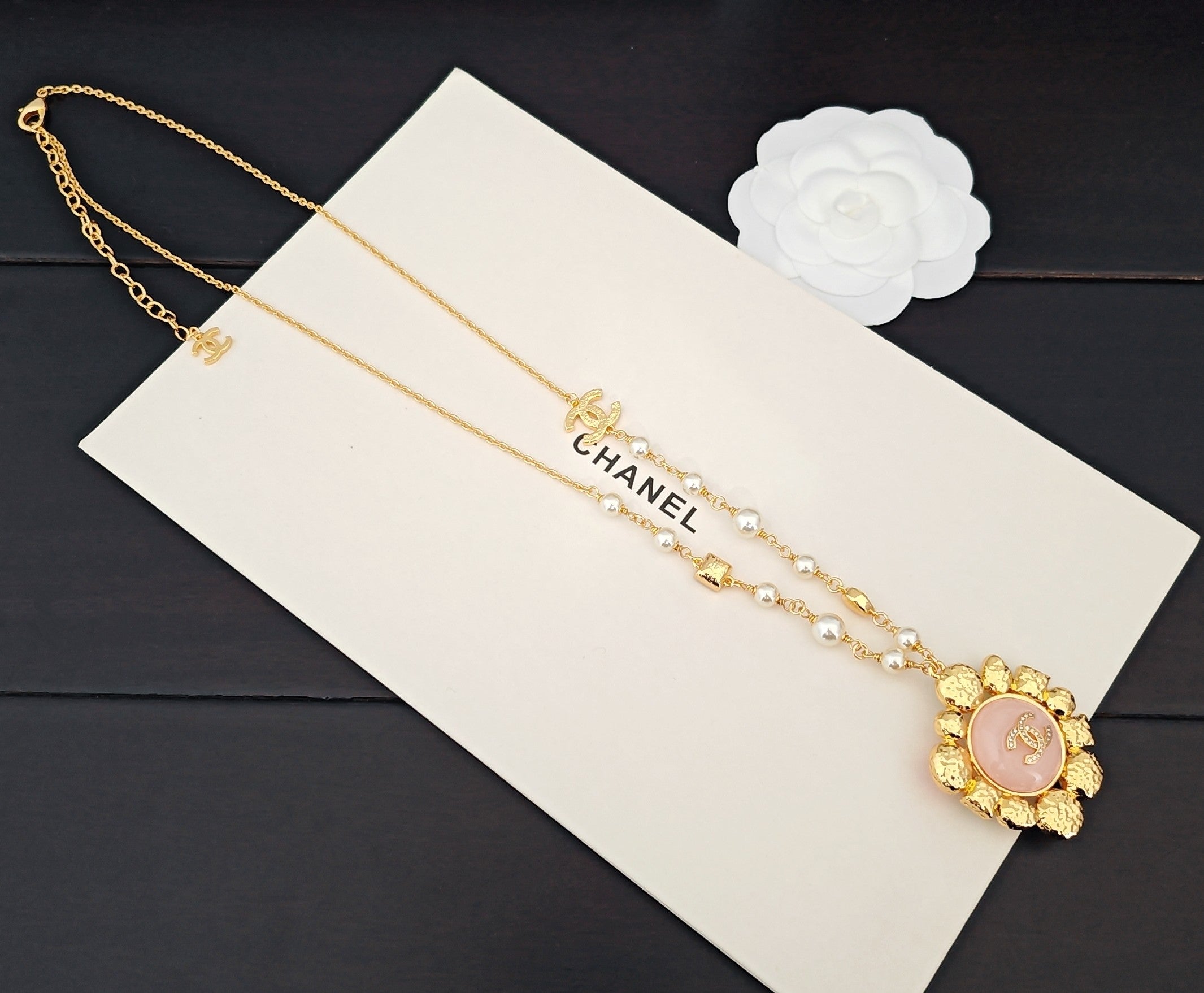 Gold-tone necklace with pearl strands, CC links, and round pink floral pendant