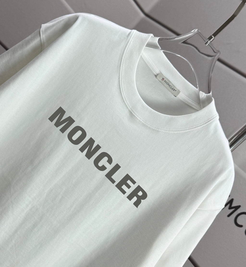 Moncler white T-shirt sleeve and front logo graphic, close-up