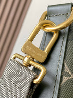 Louis Vuitton bag strap detail with gold D-ring hardware on dark green leather