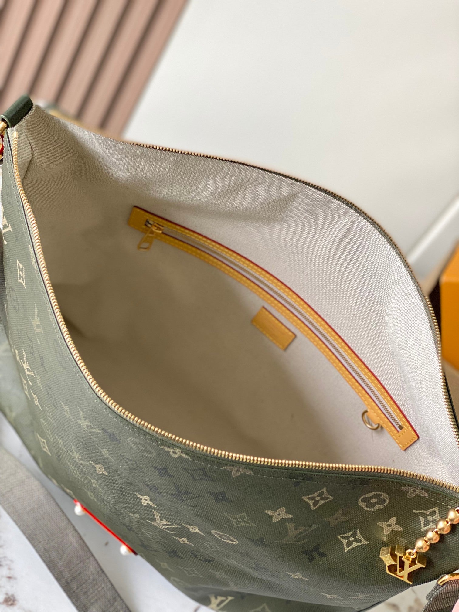 Louis Vuitton bag interior with monogram canvas, gold zipper and leather trim, open top