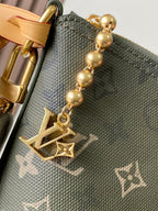 Monogram hobo bag charm detail with gold spheres and LV-style emblem