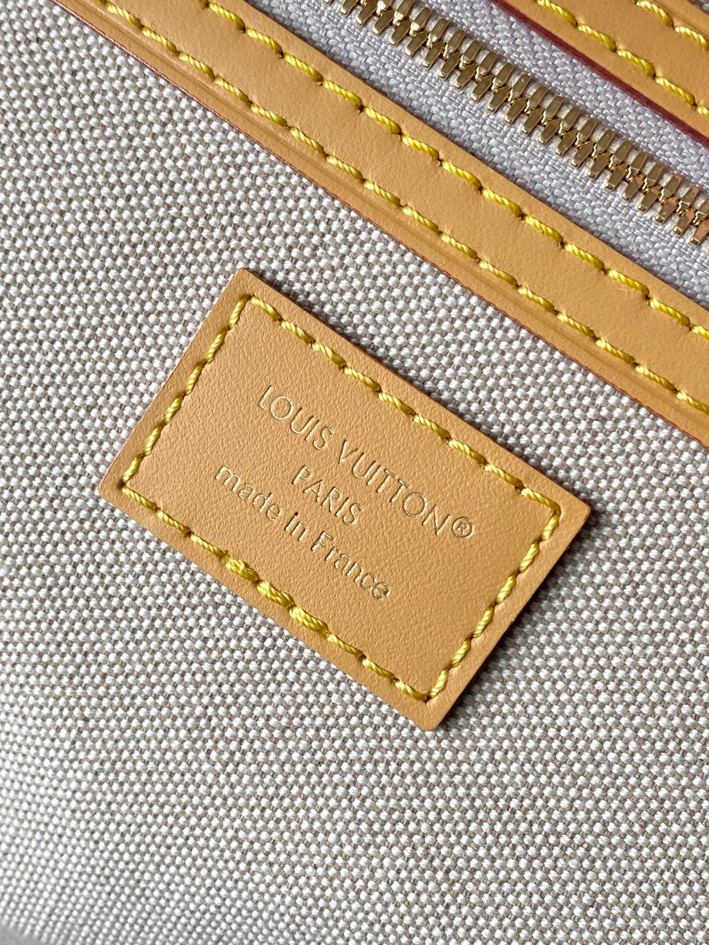 Louis Vuitton leather logo label with gold stitching and Made in France text