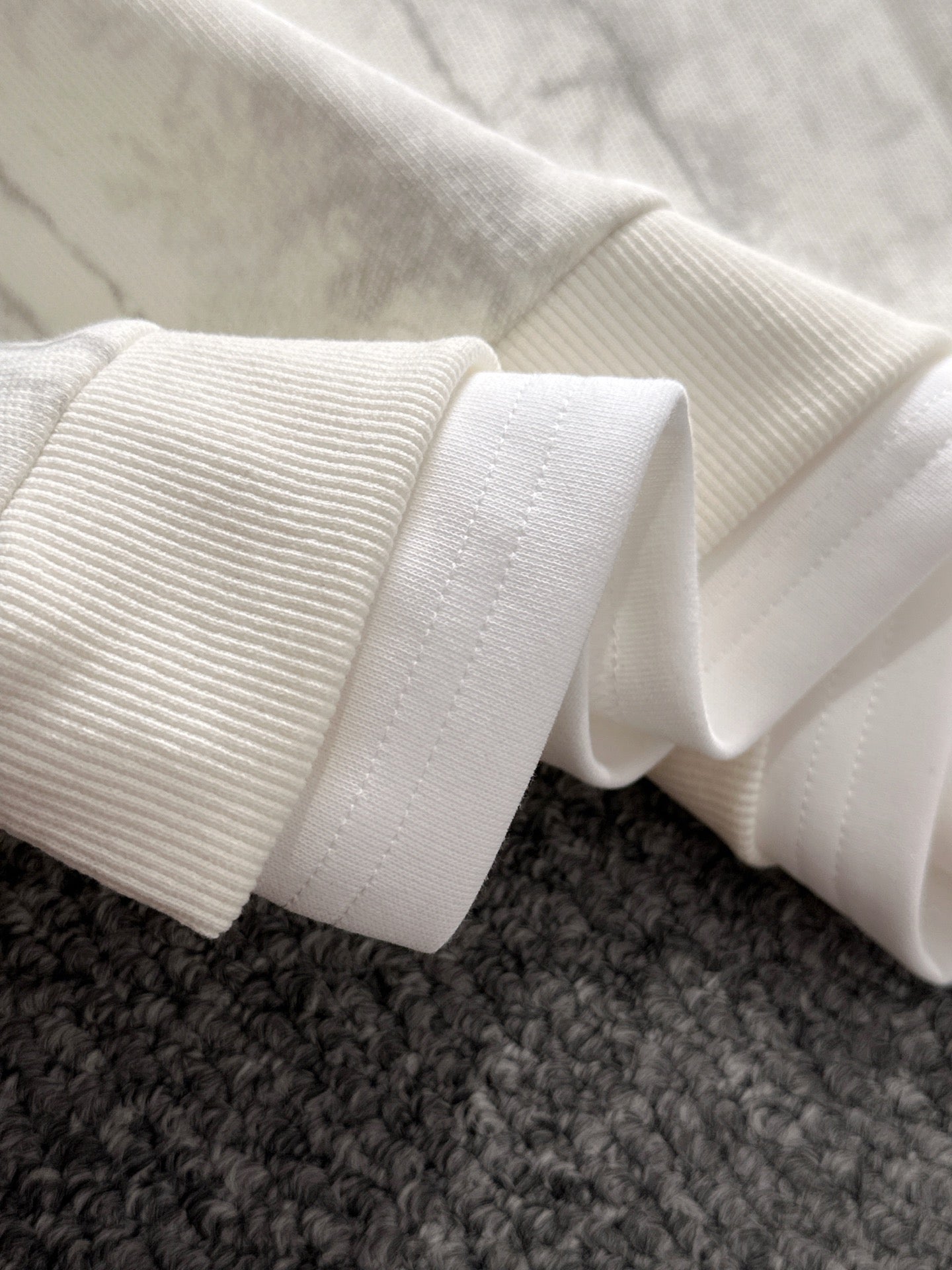 Ribbed knit cuffs and hem on marbled light sweatshirt sleeve