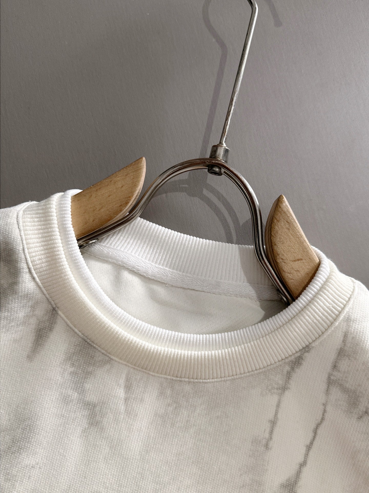Crewneck sweatshirt neckline with ribbed collar on marbled light fabric