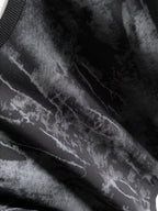 Black long-sleeve sweatshirt fabric close-up with light gray tie-dye streaks