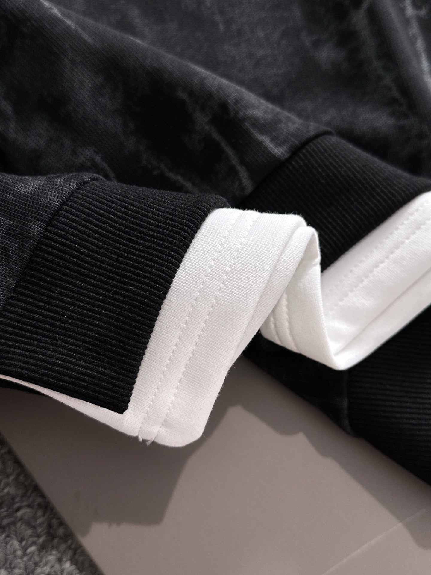 Black sweatshirt sleeve cuff and hem with white ribbed cuffs