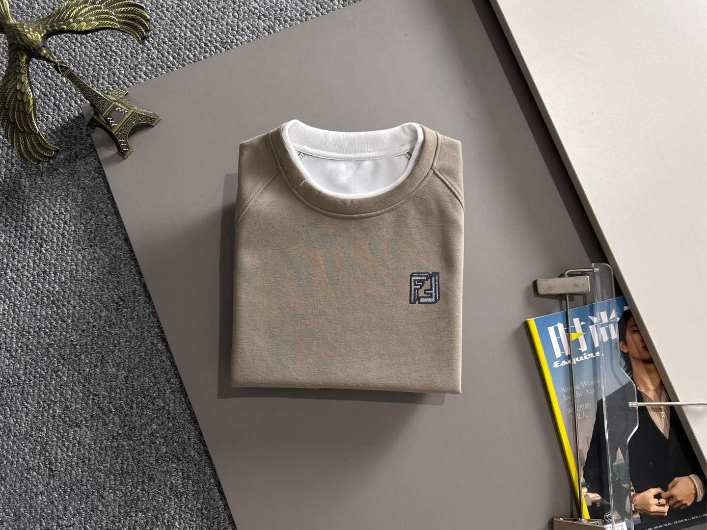 Beige crewneck sweatshirt on hanger with Fendi logo at center chest