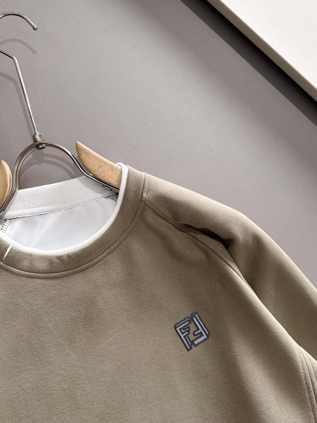 Beige crewneck sweatshirt neckline close-up with Fendi logo on chest