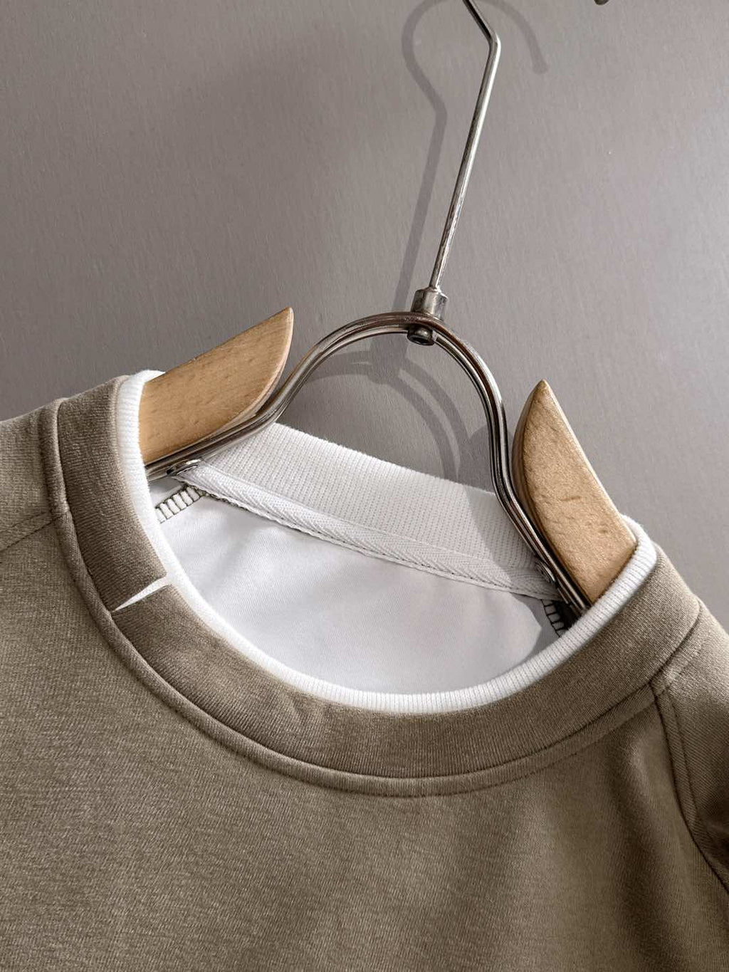 Beige crewneck sweatshirt neckline close-up on hanger