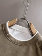 Beige crewneck sweatshirt neckline close-up on hanger