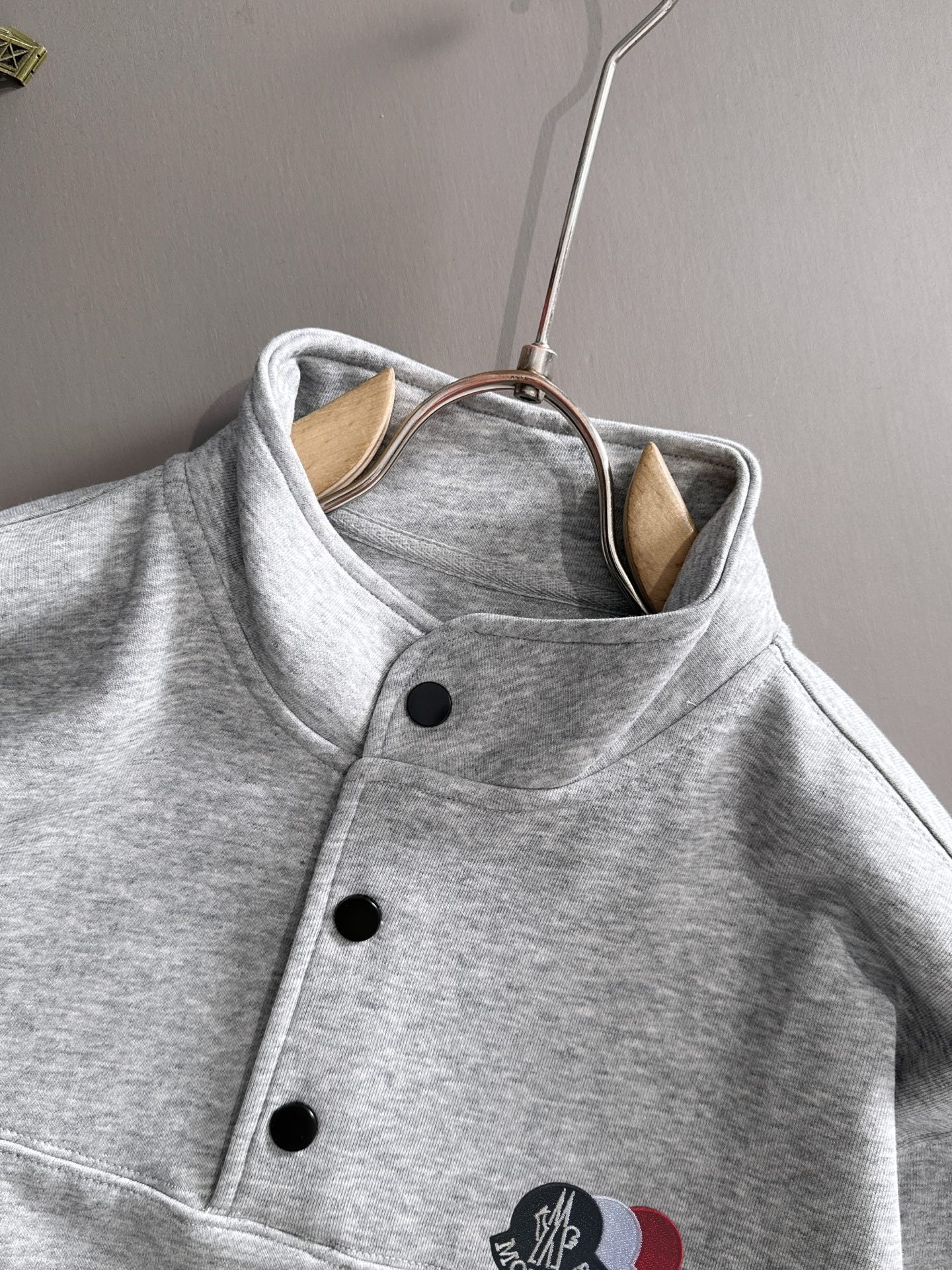 Light gray long-sleeve pullover with stand collar and logo patch