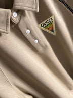 Cream polo shirt with Gucci logo patch and white button placket