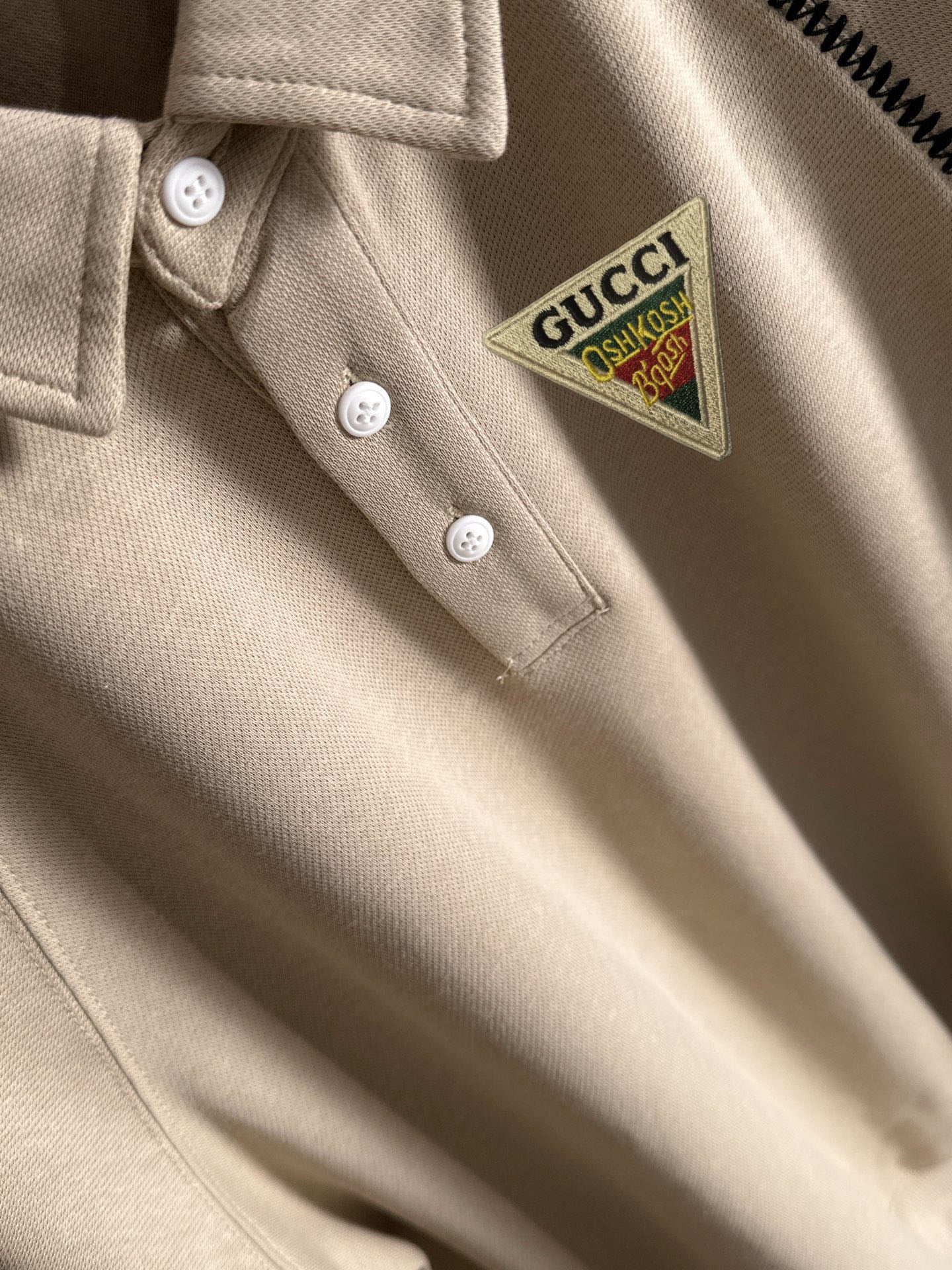 Cream polo shirt with Gucci logo patch and white button placket