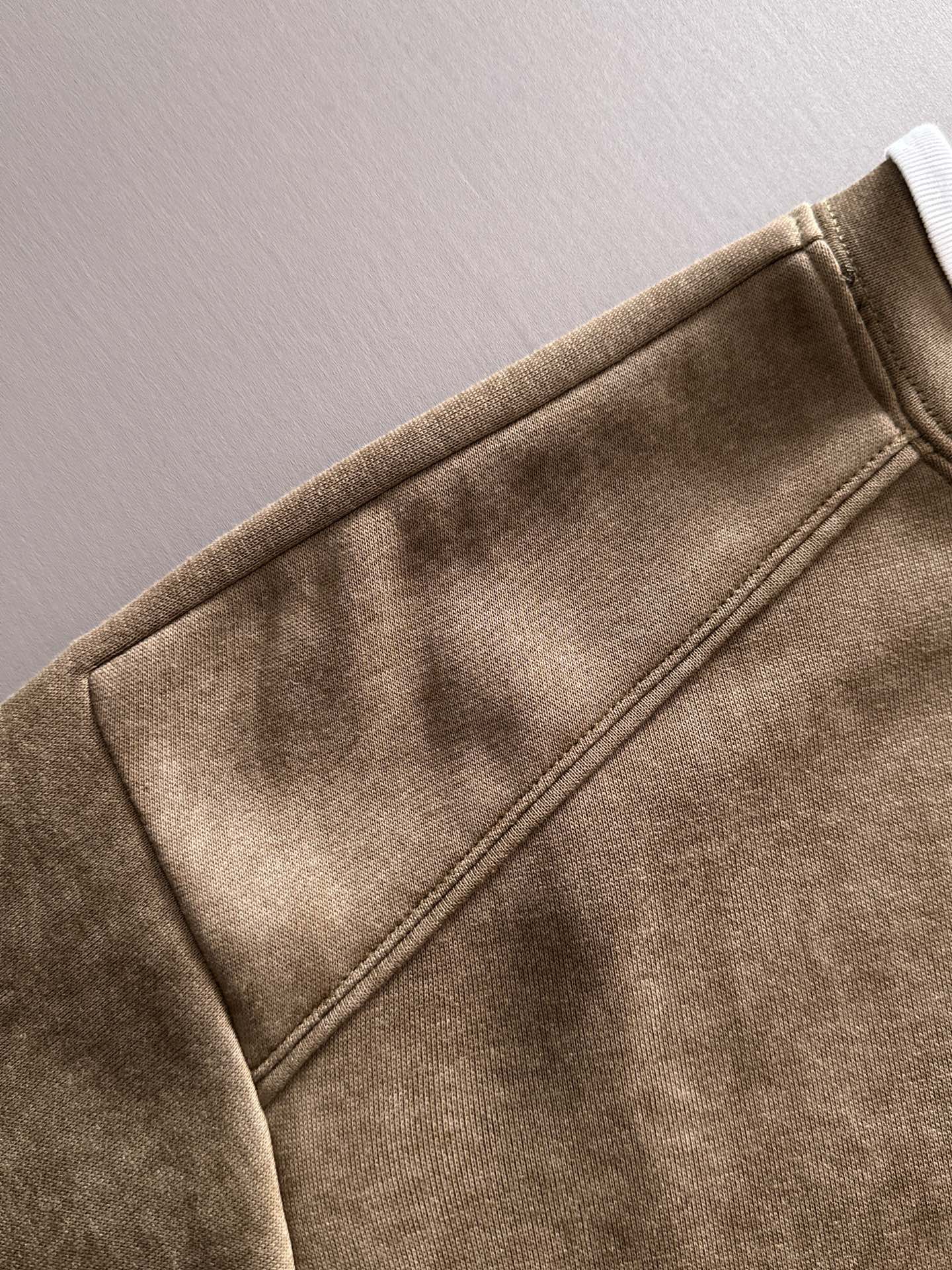 Gucci long-sleeve top sleeve close-up with stitched seams and soft brown fabric
