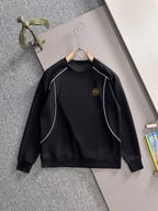 Black long-sleeve sweatshirt with white piping and small gold logo emblem