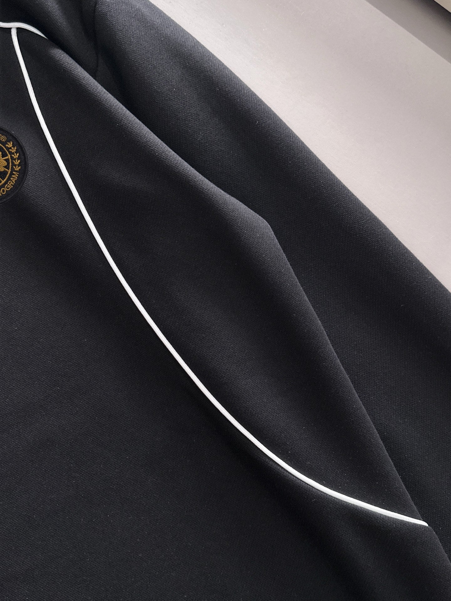 Black sweatshirt panel with white contrast seam piping