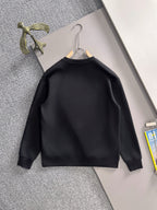 Black long-sleeve sweatshirt with white piping and gold emblem on hanger