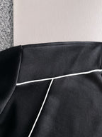 Black sweatshirt panel with white piping trim along the seam