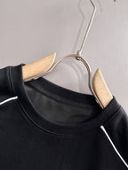 Black crew-neck sweatshirt with white stripe trim on hanger
