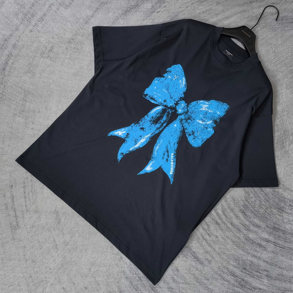 Balenciaga black T-shirt laid flat, blue bow graphic on front