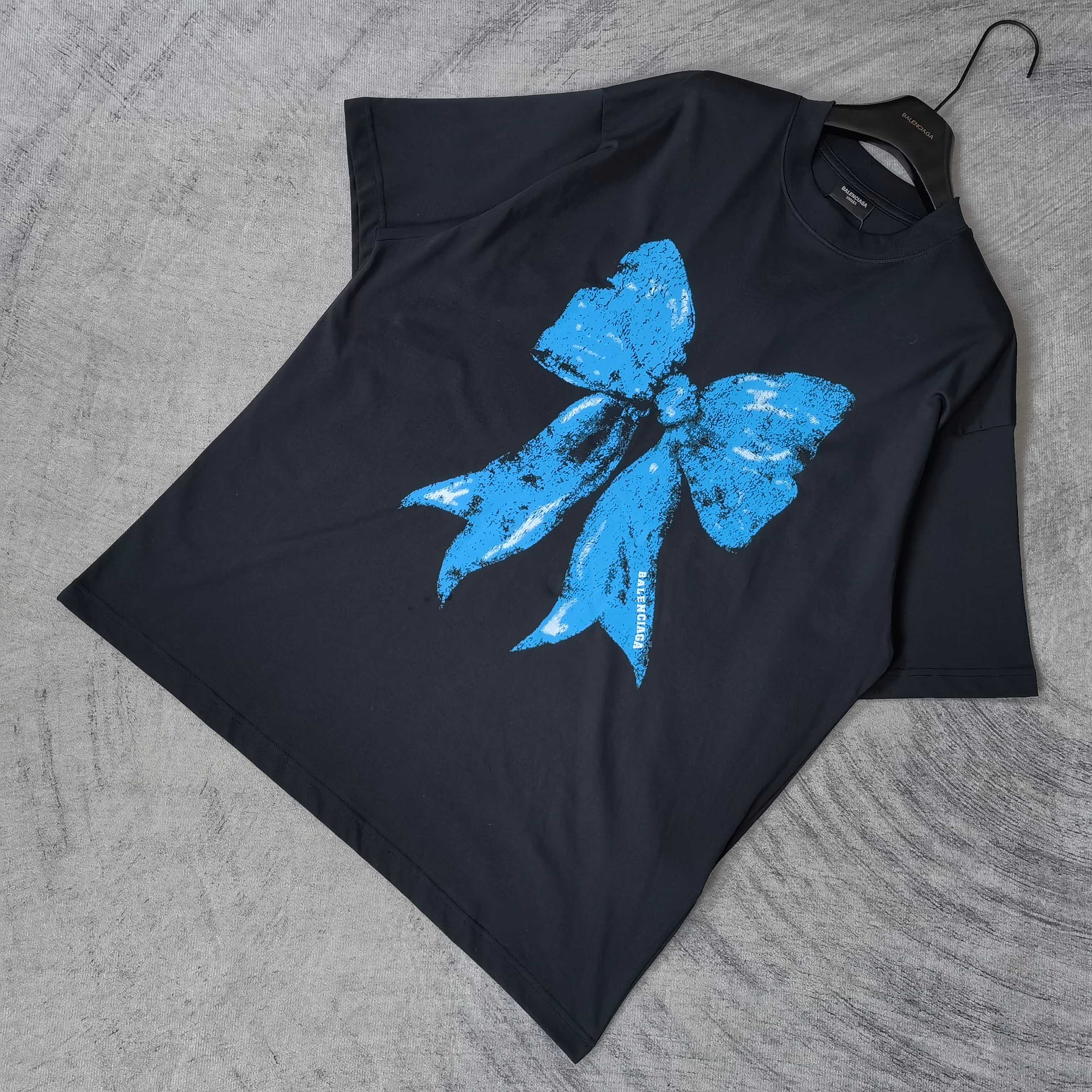 Balenciaga black T-shirt laid flat, blue bow graphic on front