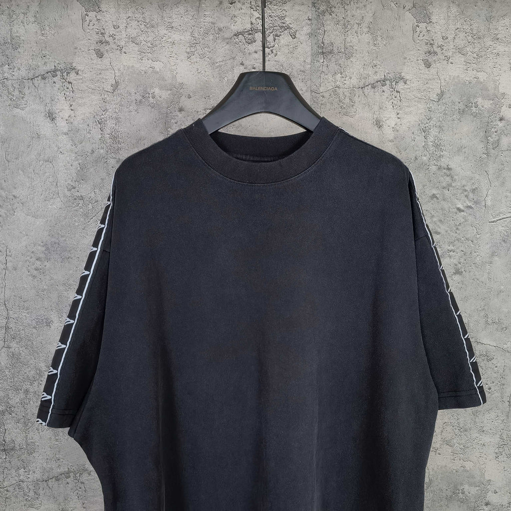 Balenciaga short-sleeve T-shirt close view, dark crew neck and striped sleeve panels