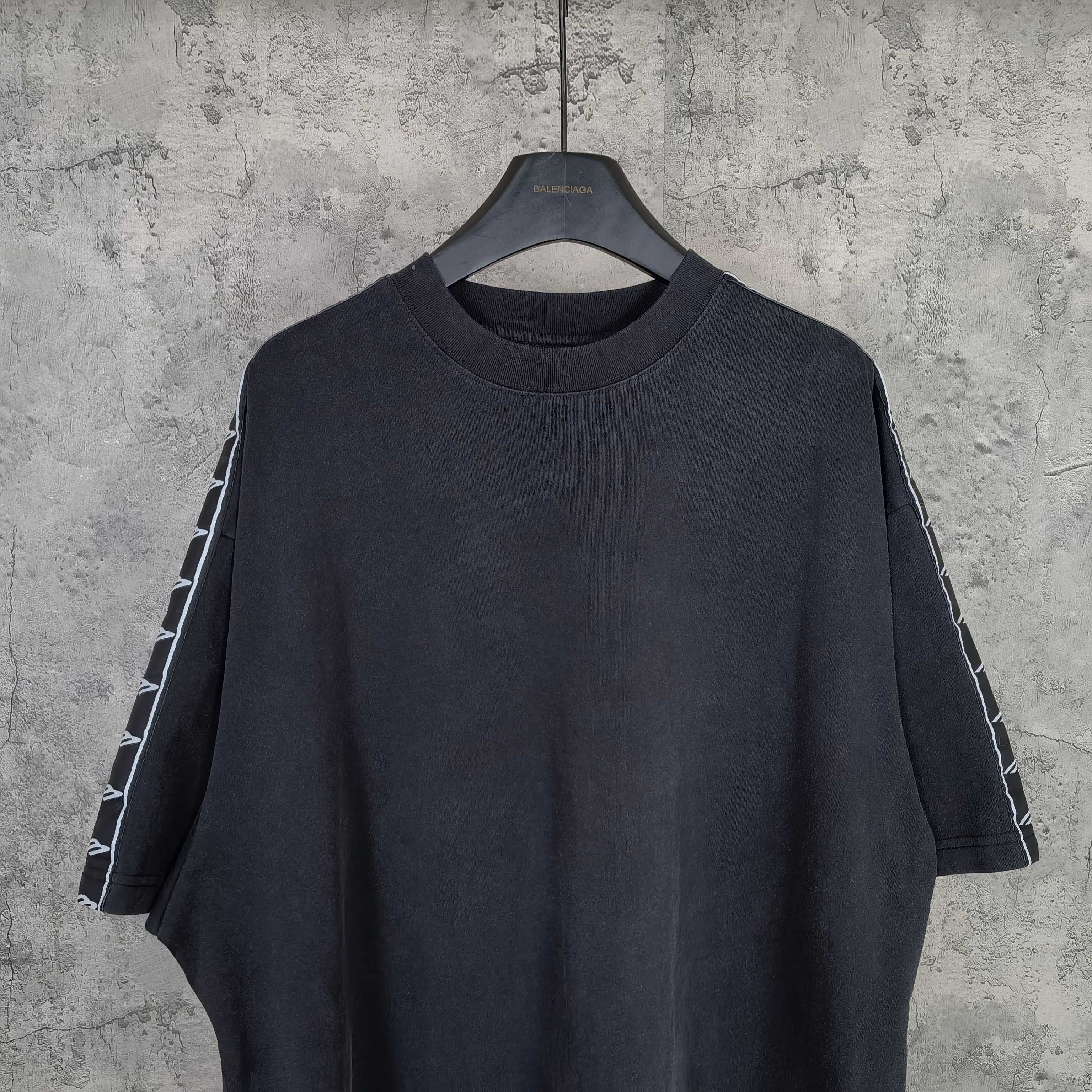 Balenciaga short-sleeve T-shirt close view, dark crew neck and striped sleeve panels