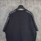 Balenciaga short-sleeve T-shirt back view, dark with contrast striped sleeve details