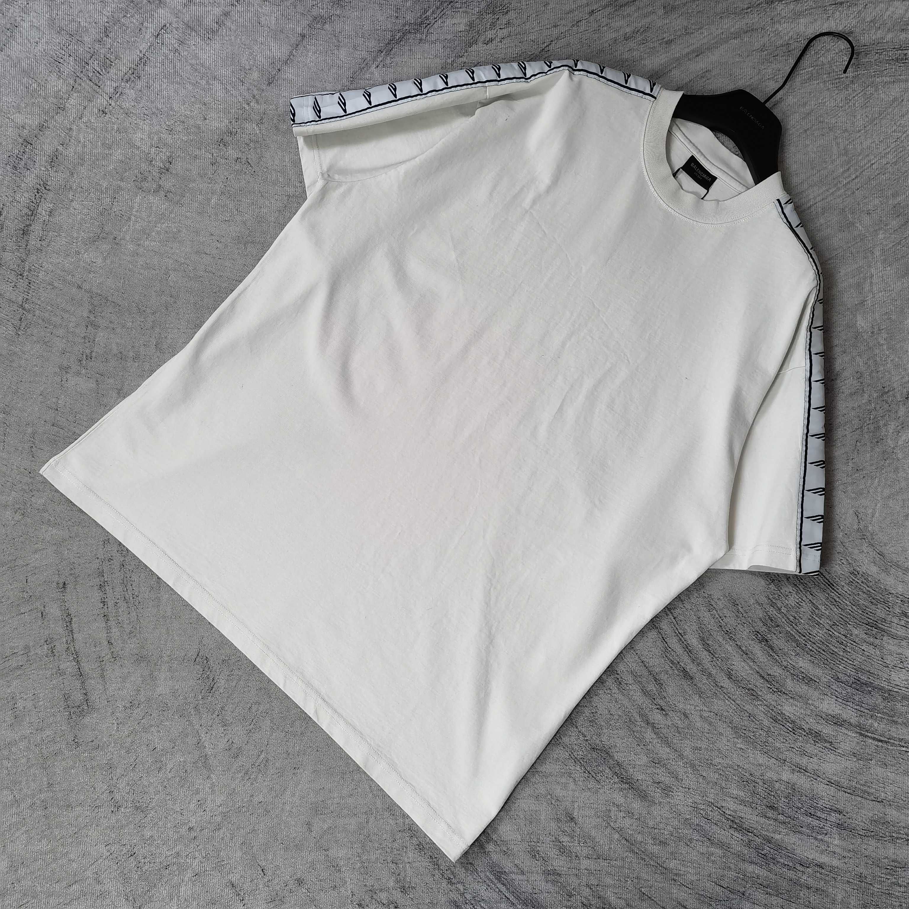 Balenciaga white short-sleeve T-shirt laid flat, patterned stripe trim at sleeves