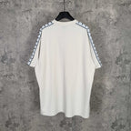 Balenciaga white crewneck T-shirt, back view, with patterned stripe sleeve trim