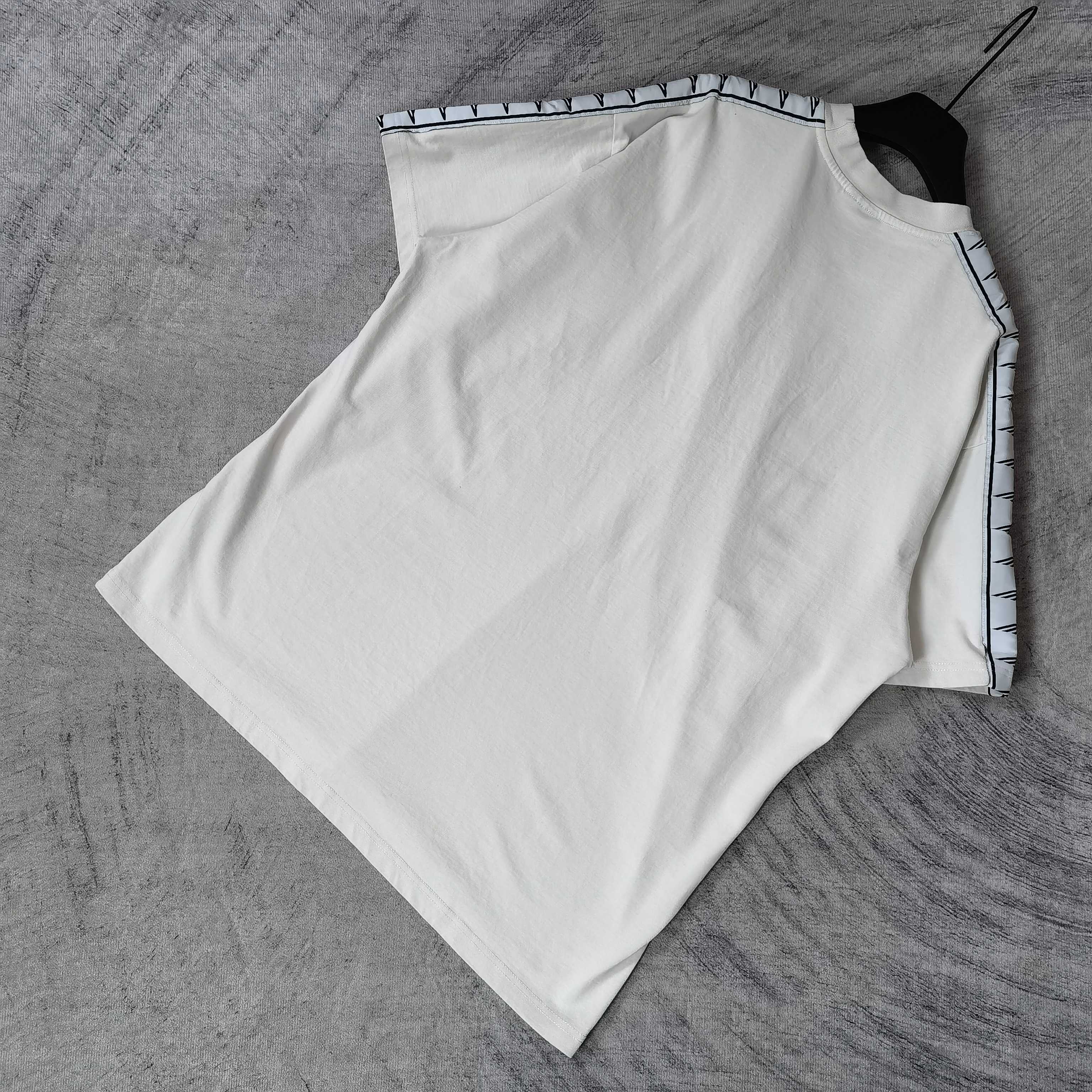 Balenciaga white short-sleeve T-shirt flat lay, patterned stripe trim along sleeves